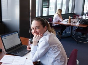 Student smiling at camera inside Chicago Kent Library